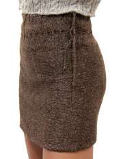 Close-up of a short brown winter alpaca knit skirt, worn with the plain side out and ties at the waist, model Giuditta.