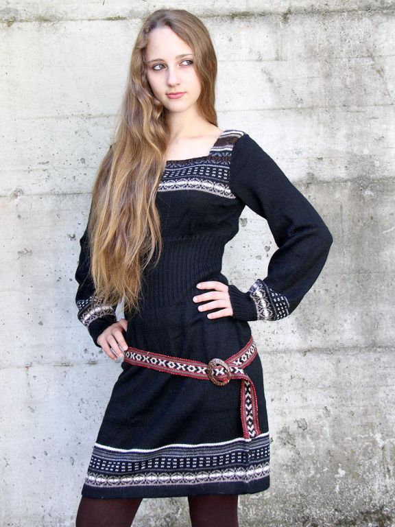 Woman wearing a short black alpaca dress with long sleeves and jacquard pattern, model Giuditta.